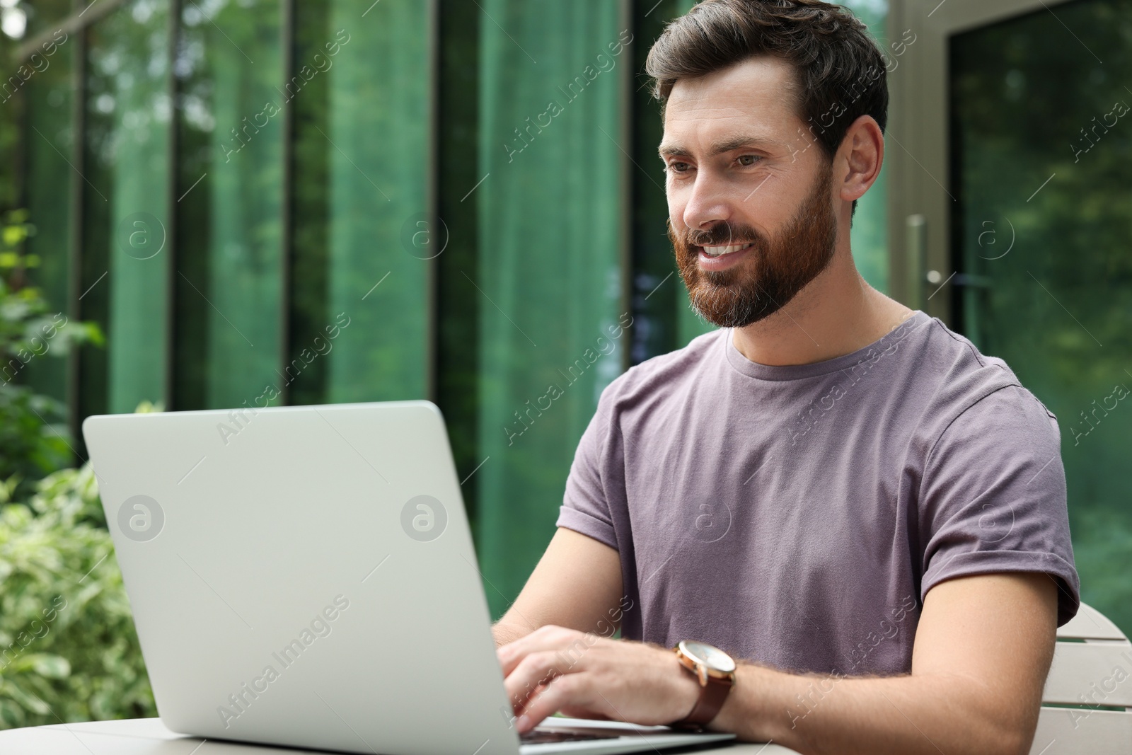 Photo of Handsome man with laptop in outdoor cafe