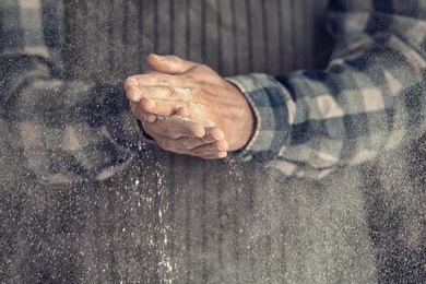 Photo of Man clapping hands and sprinkling flour, closeup