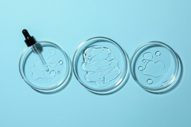 Photo of Petri dishes and pipette on light blue background, flat lay