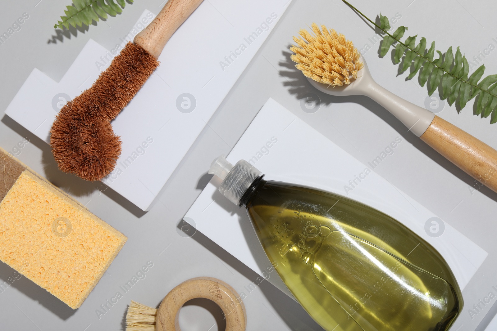 Photo of Flat lay composition with different cleaning supplies on light gray background