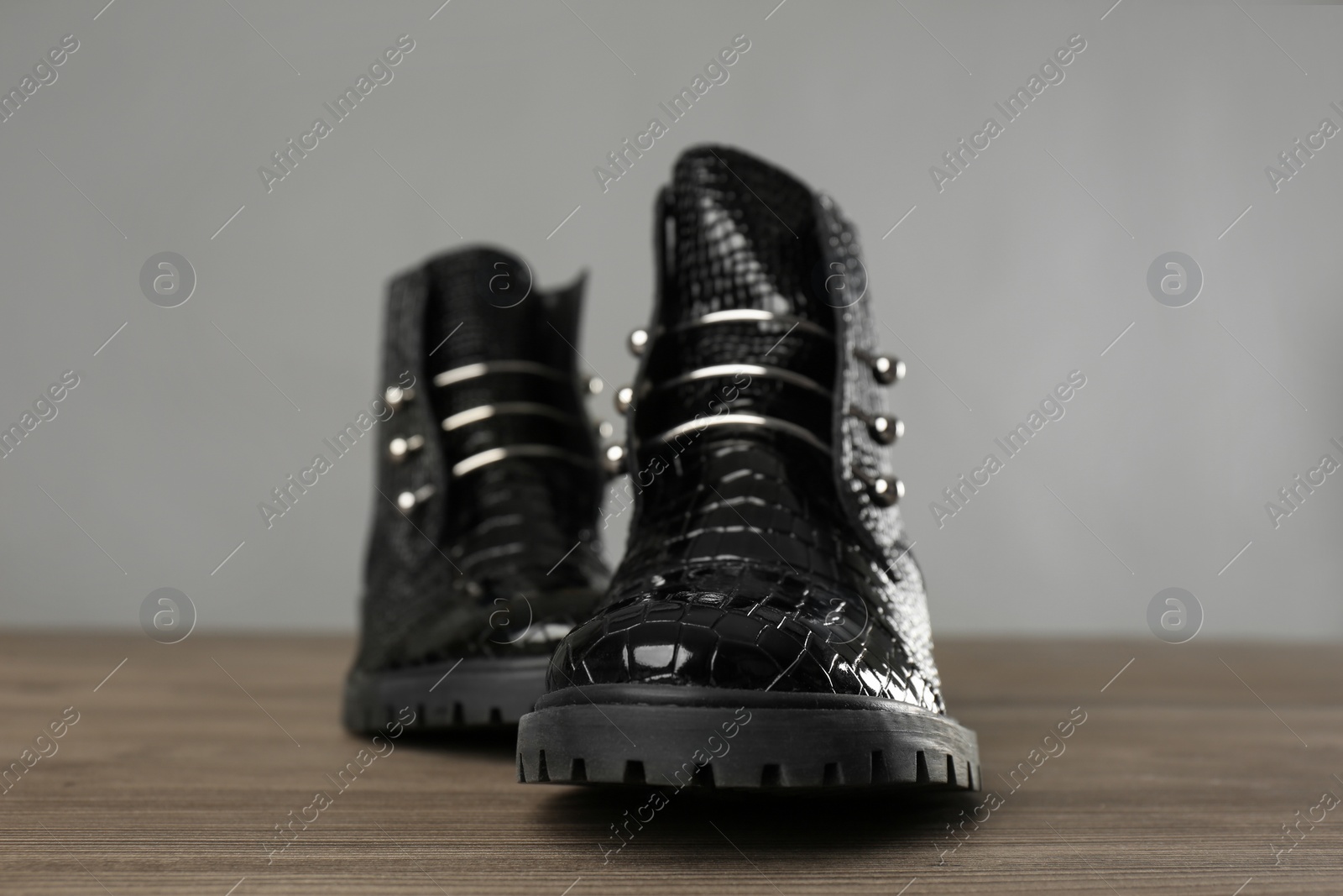 Photo of Pair of stylish ankle boots on wooden background, closeup