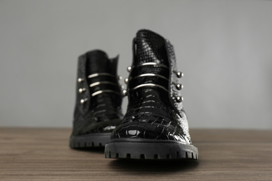 Pair of stylish ankle boots on wooden background, closeup