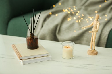 Photo of Different decor and air reed diffuser on white marble table indoors. Interior design