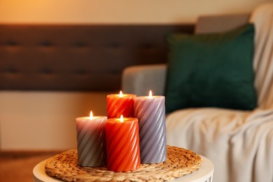 Photo of Burning candles on table indoors. Cosy atmosphere