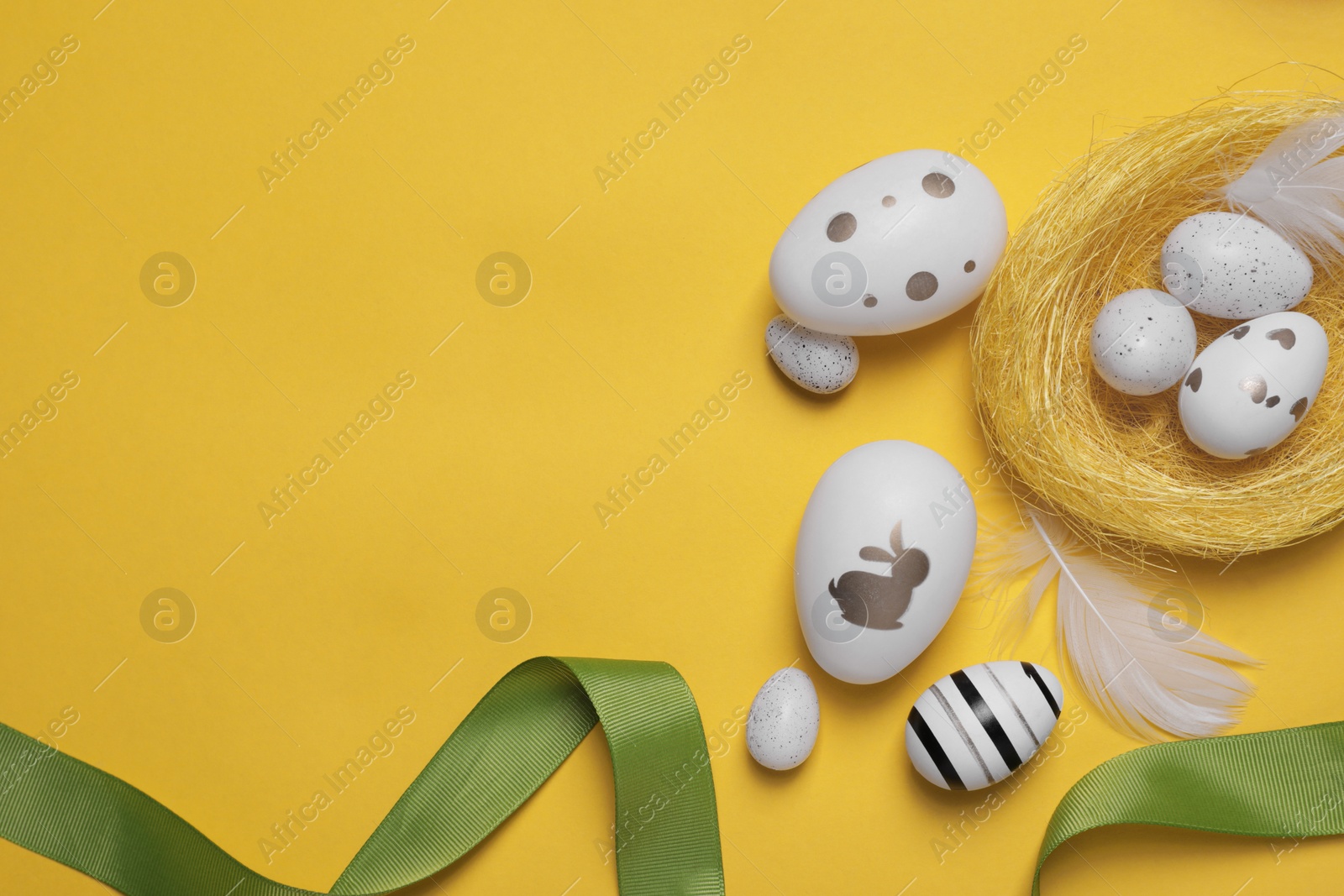 Photo of Flat lay composition with festively decorated Easter eggs on yellow background. Space for text