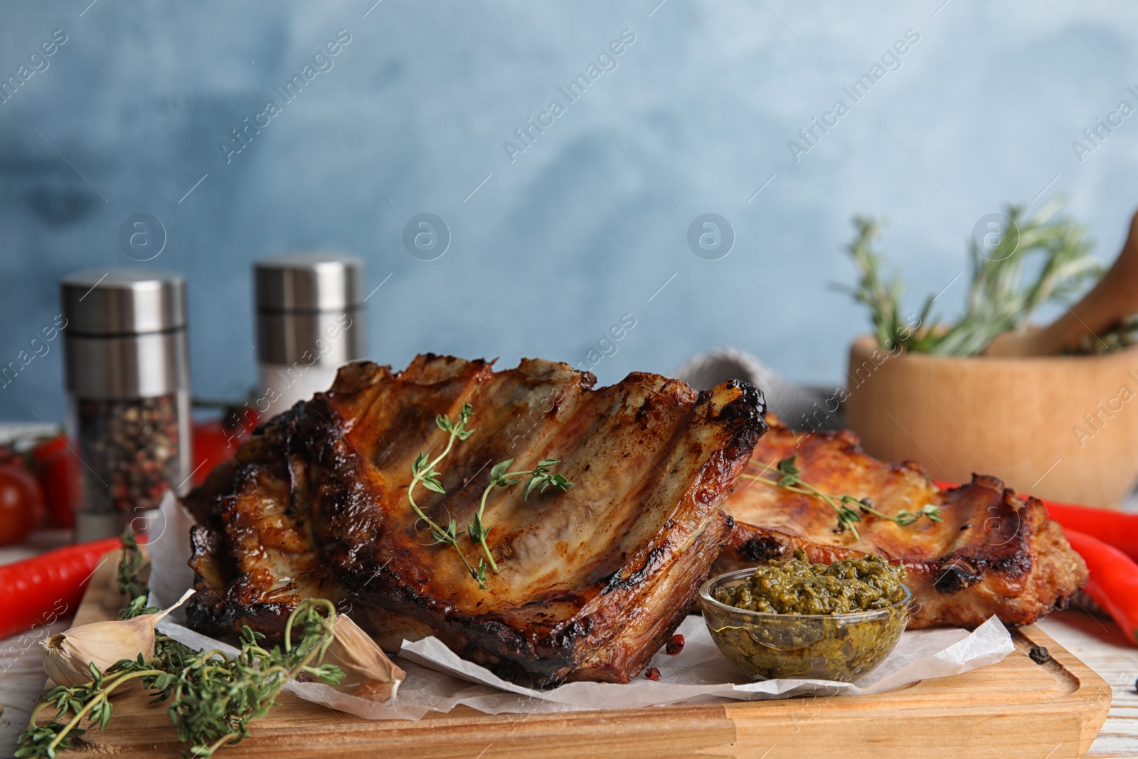 Photo of Tasty aromatic grilled ribs with thyme served on table