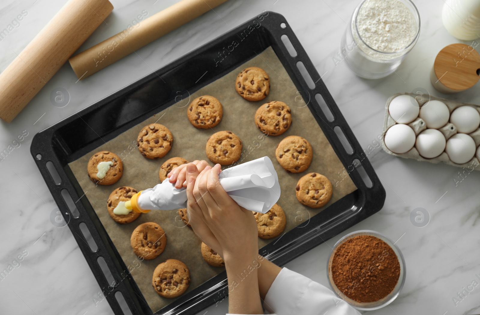 Photo of Woman preparing biscuits at white marble table, top view. Cooking delicious food