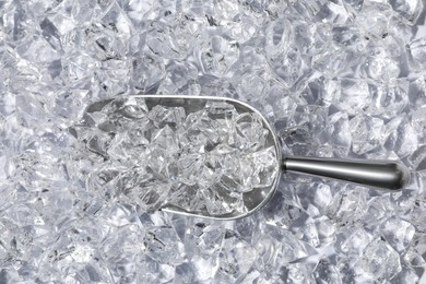 Photo of Metal scoop on crushed ice, top view