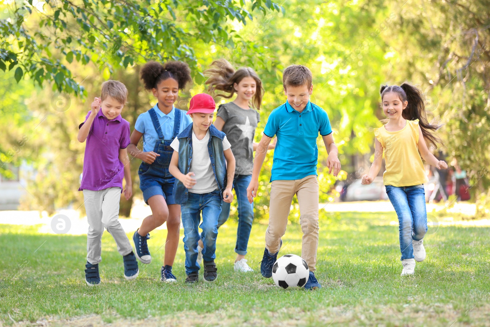 Photo of Cute little children playing with ball outdoors on sunny day