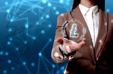 Image of Cryptocurrency. Businesswoman holding illustration of Litecoin against blue background, closeup