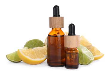Photo of Bottles of citrus essential oil and cut fresh fruits isolated on white