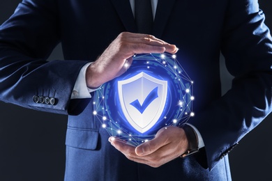 Cyber insurance concept. Man demonstrating shield illustration as symbol of protection, closeup