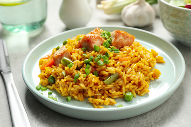 Photo of Delicious rice pilaf with vegetables and chicken on light grey table