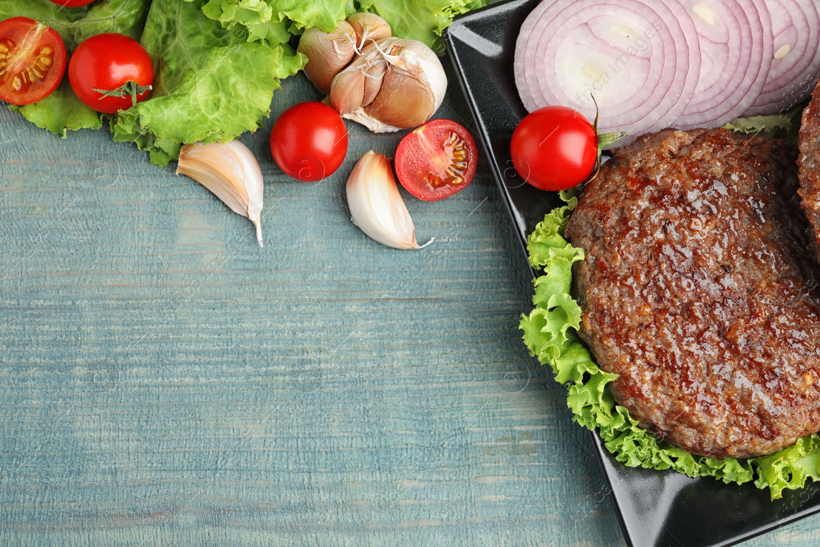 Photo of Flat lay composition with grilled meat cutlet for burger on blue wooden table. Space for text