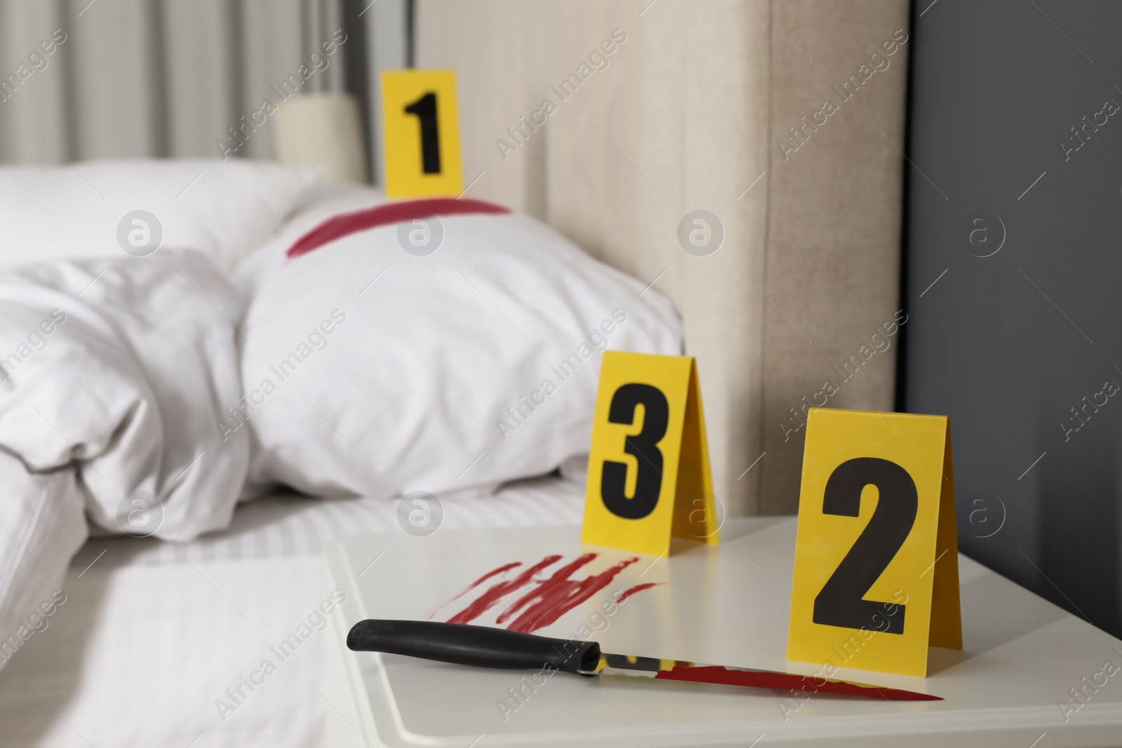 Photo of Bloody knife and crime scene markers on nightstand in bedroom