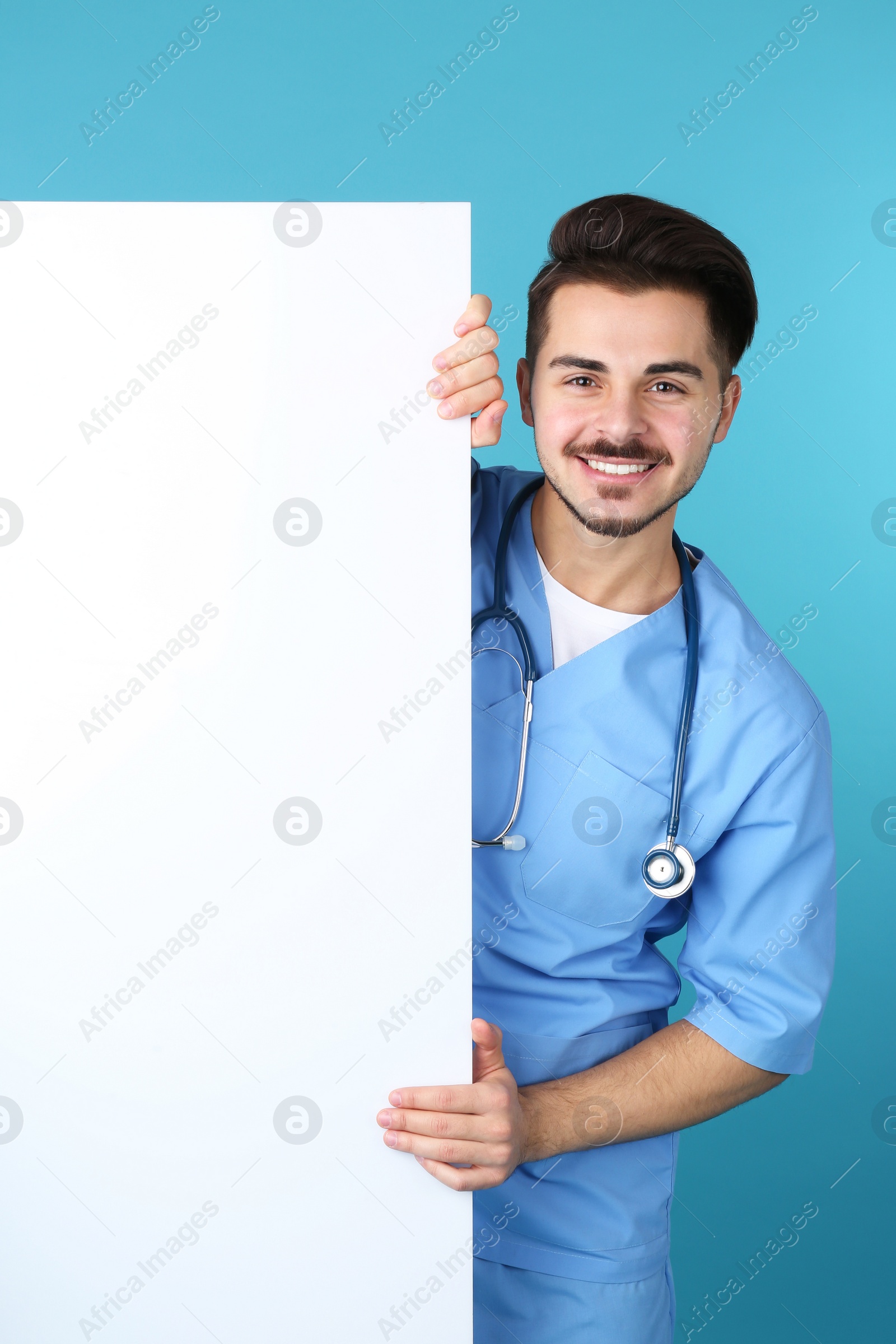 Photo of Medical student with blank poster on color background. Space for text