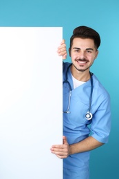 Medical student with blank poster on color background. Space for text