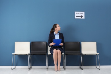 Photo of Young woman waiting for job interview, indoors