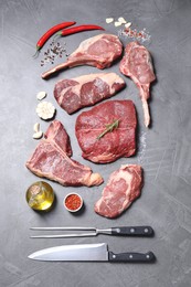 Photo of Fresh raw beef cuts, spices and butcher tools on light grey textured table, flat lay