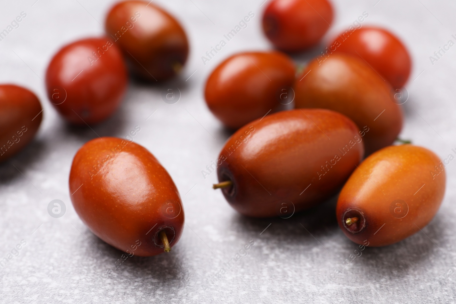 Photo of Fresh Ziziphus jujuba fruits on light table, closeup