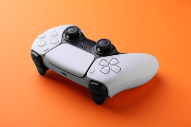 Photo of One wireless game controller on orange background