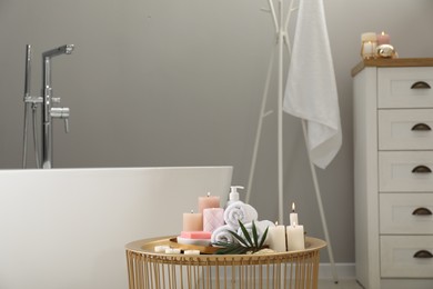 Stylish bathroom interior with ceramic tub and spa products on table