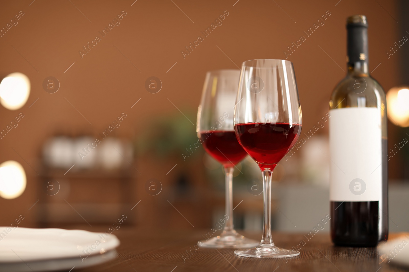 Photo of Glasses and bottle with tasty wine on table in restaurant