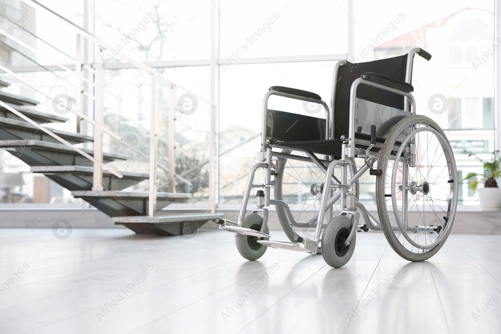 Photo of Modern wheelchair in empty room, space for text. Medical equipment