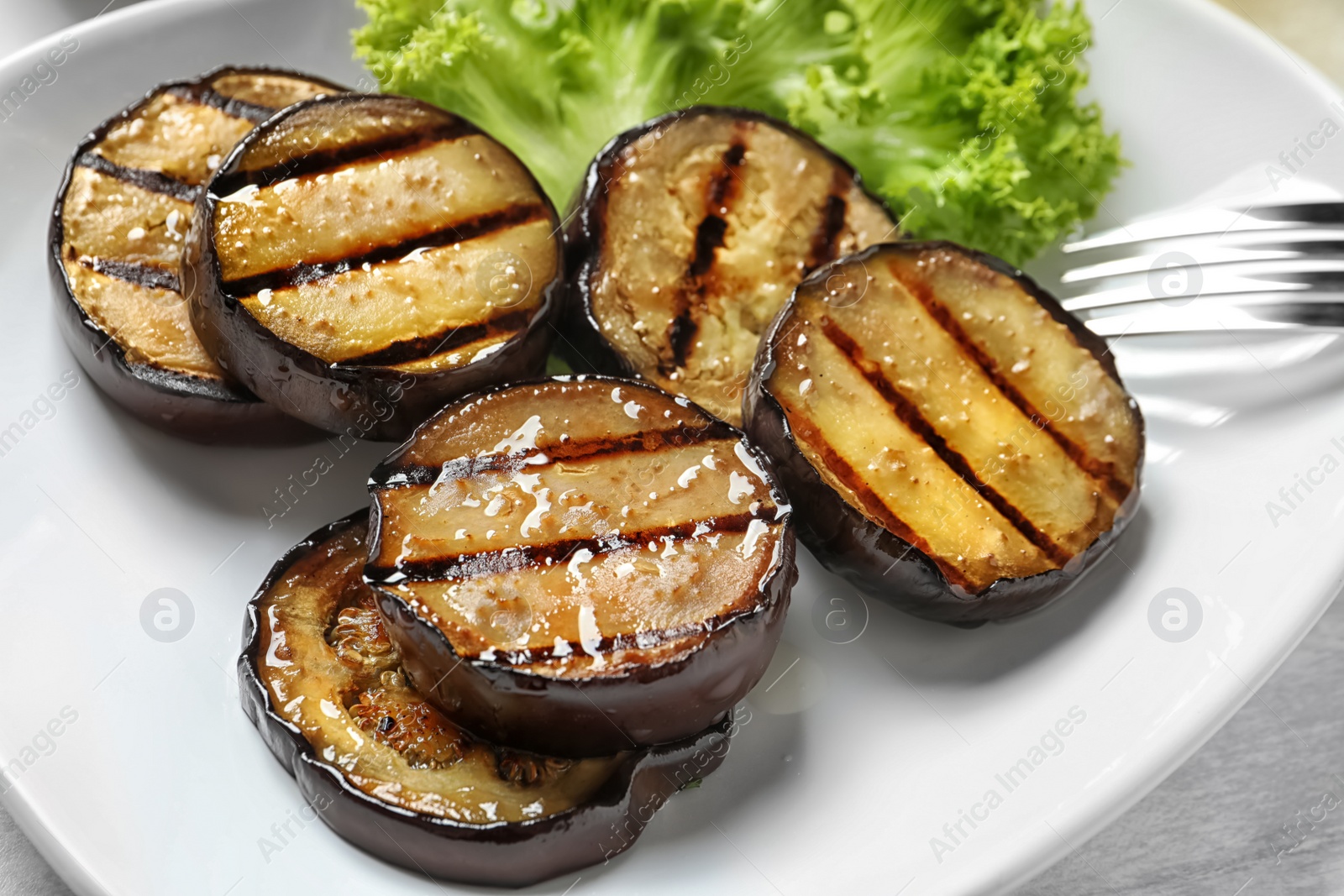 Photo of Plate with tasty fried eggplant slices, closeup