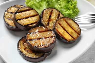 Plate with tasty fried eggplant slices, closeup