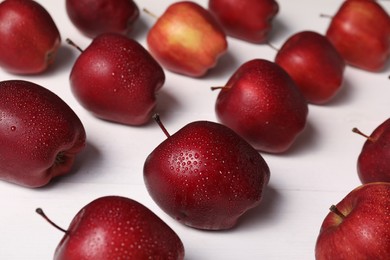 Photo of Fresh red apples with water drops on white wooden table, closeup