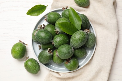 Flat lay composition with fresh green feijoa fruits on white wooden table