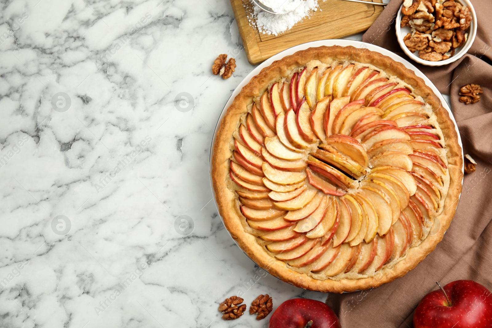 Photo of Delicious homemade apple tart and ingredients on white marble table, flat lay. Space for text