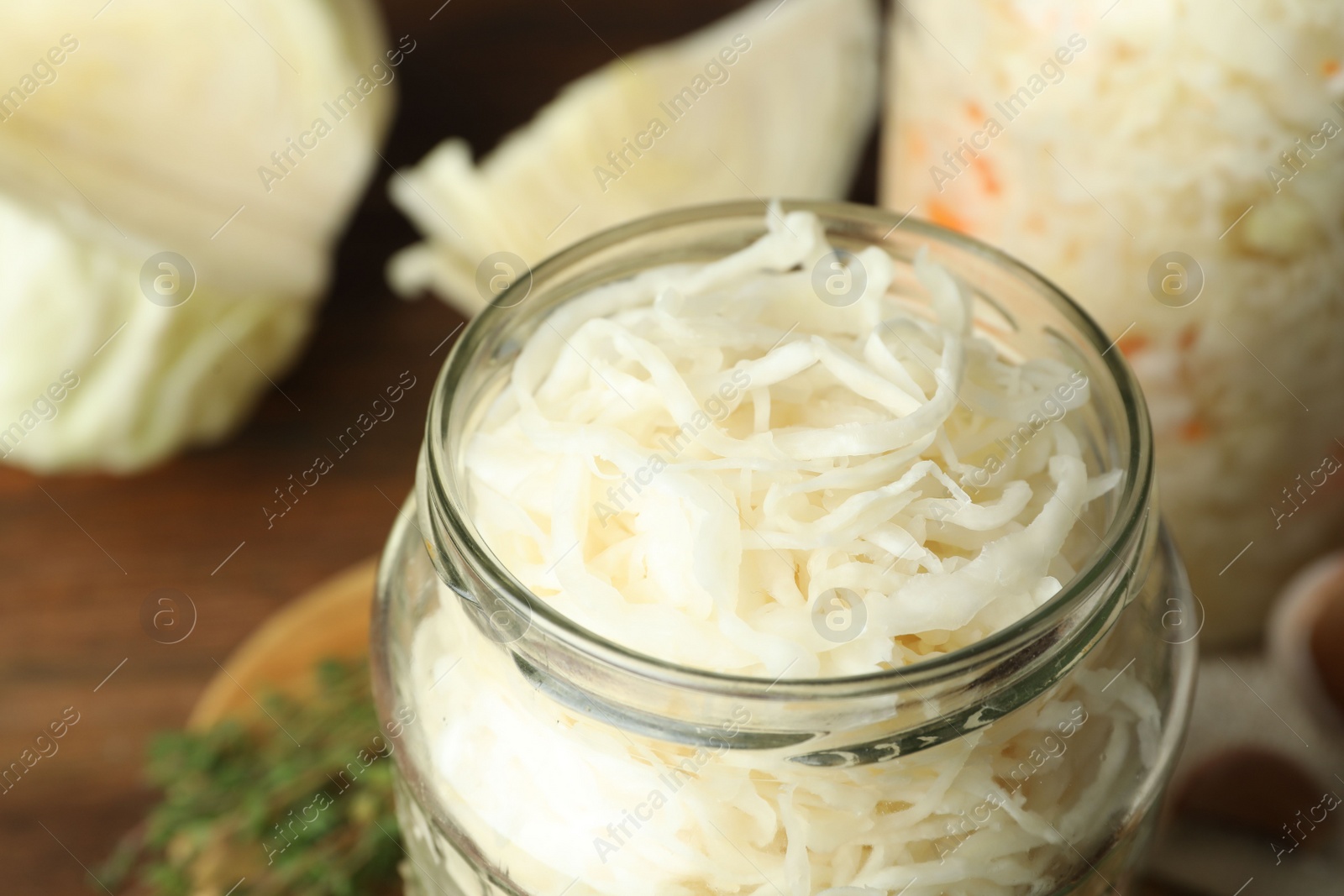 Photo of Jar of tasty fermented cabbage on table, closeup