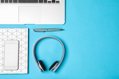 Photo of Flat lay composition with headphones, laptop and space for text on color background