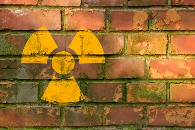 Image of Radioactive sign on brick wall, space for text. Hazard symbol