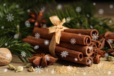 Image of Different spices and fir tree branches on wooden table, closeup. Cinnamon, anise, cardamom, nutmeg