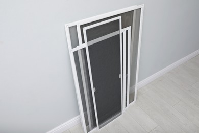 Photo of Set of window screens near light grey wall indoors, above view