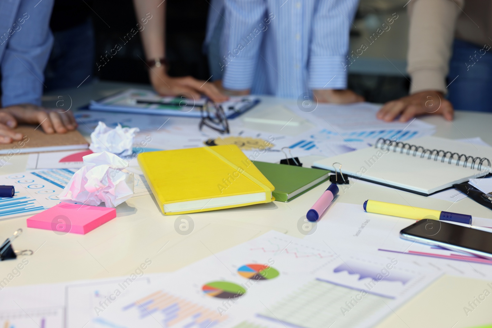 Photo of Team of employees working with charts at table, closeup. Startup project