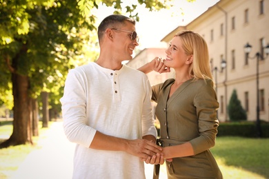 Happy couple walking along city street on summer day