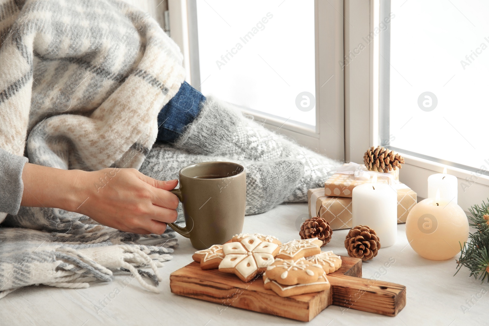 Photo of Woman relaxing with cup of hot winter drink near window. Cozy season