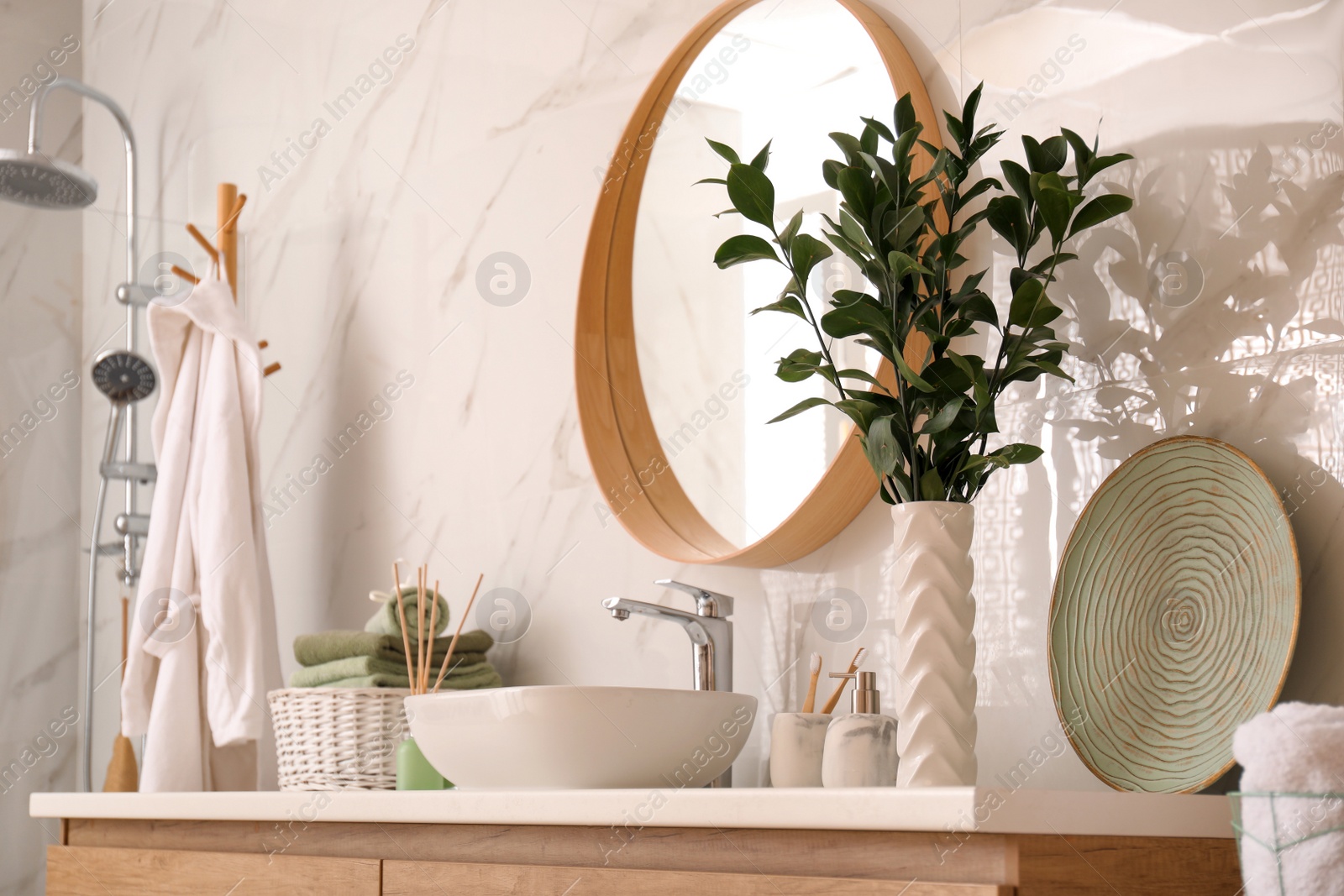 Photo of Vase with beautiful branches and toiletries near vessel sink in bathroom. Interior design