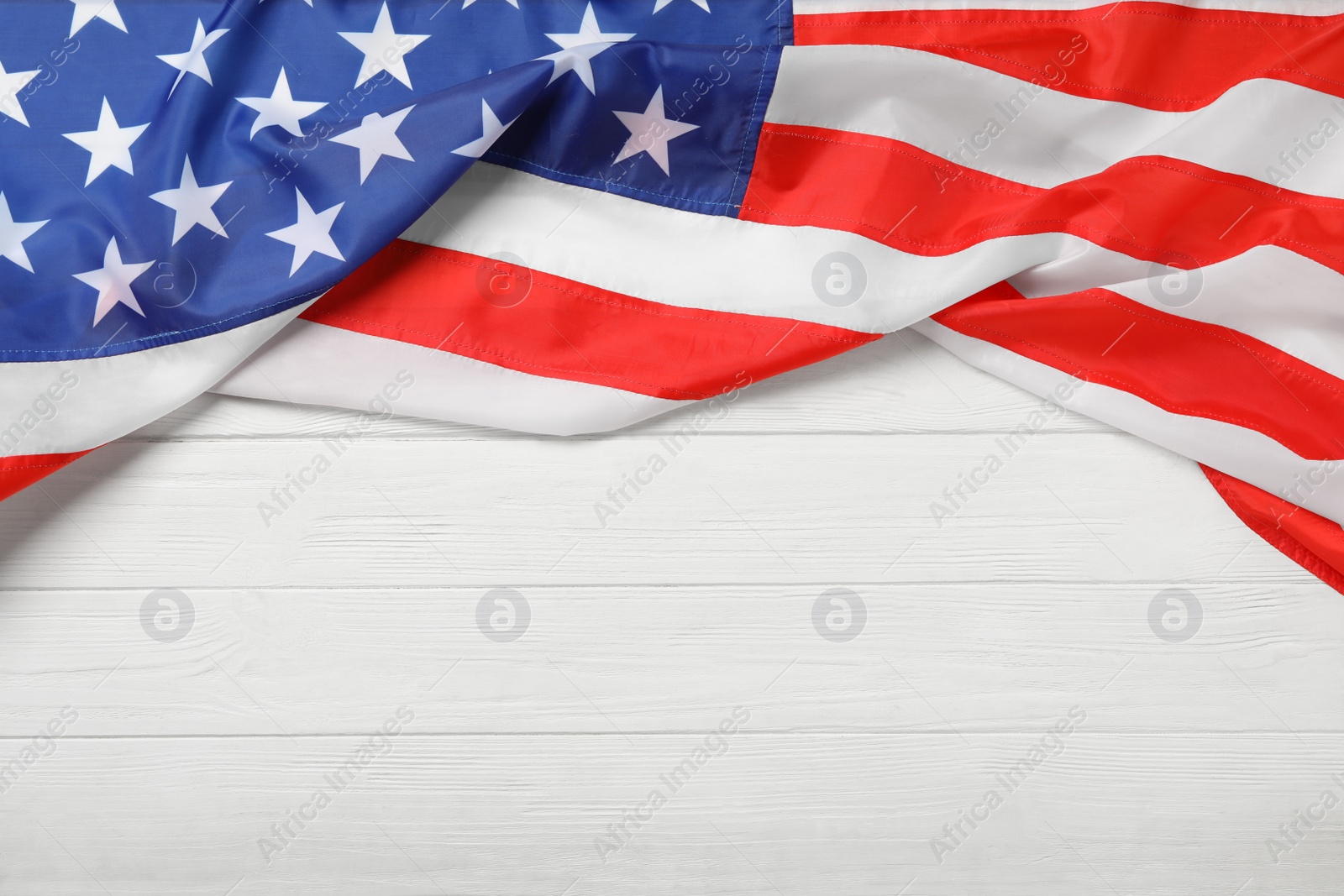 Photo of American flag on white wooden table, top view with space for text. Memorial Day