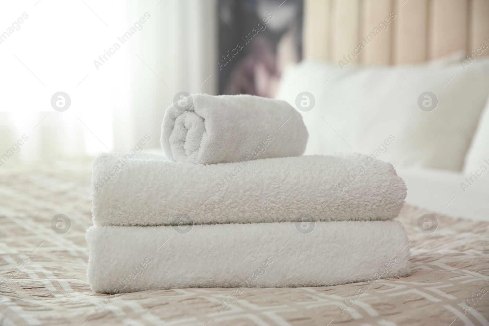 Photo of Clean white towels on bed at home