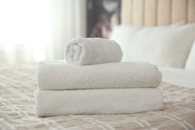 Clean white towels on bed at home