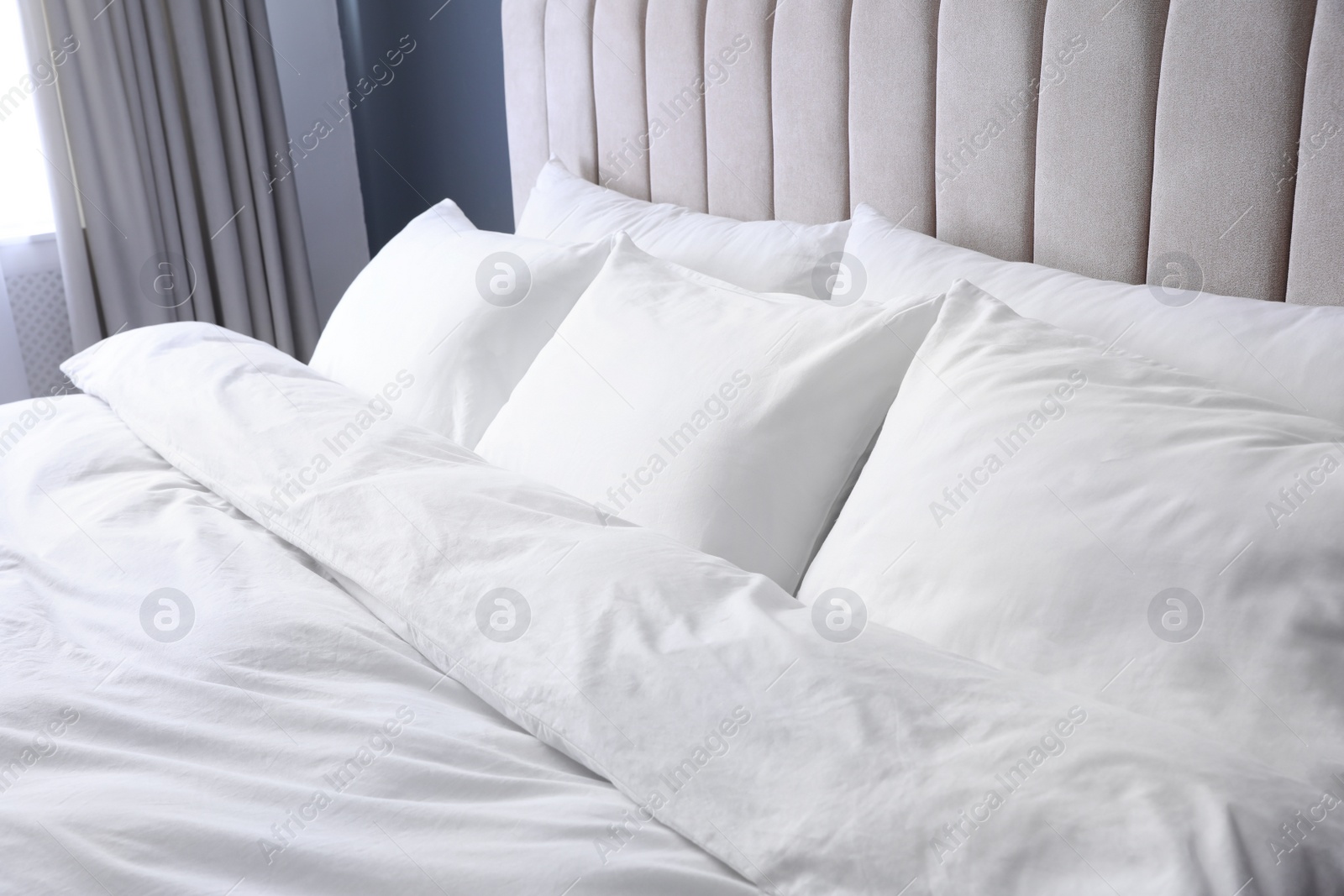 Photo of Comfortable bed with soft pillows indoors, closeup