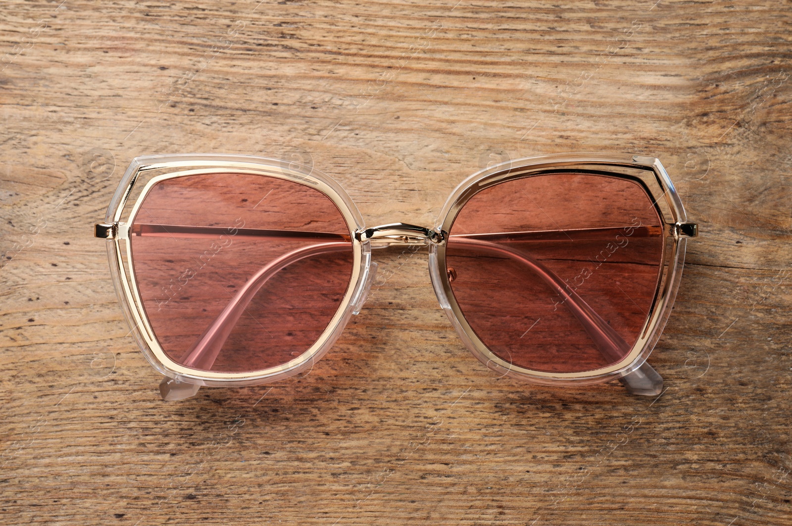 Photo of New stylish sunglasses on wooden table, top view