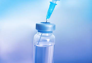 Vial and syringe on blurred background. Vaccination and immunization