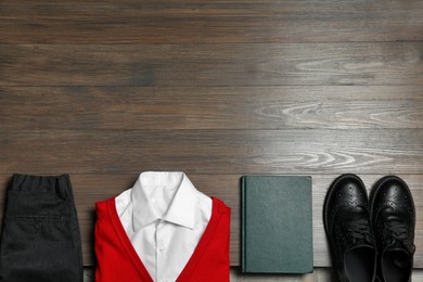 Photo of Stylish school uniform and notebook on wooden background, flat lay. Space for text