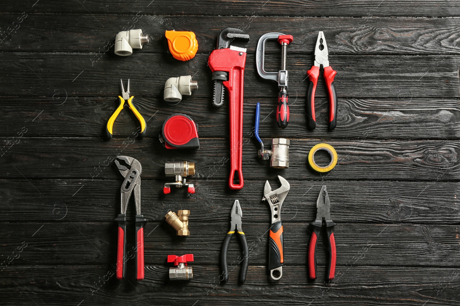 Photo of Flat lay composition with plumber's tools on wooden background